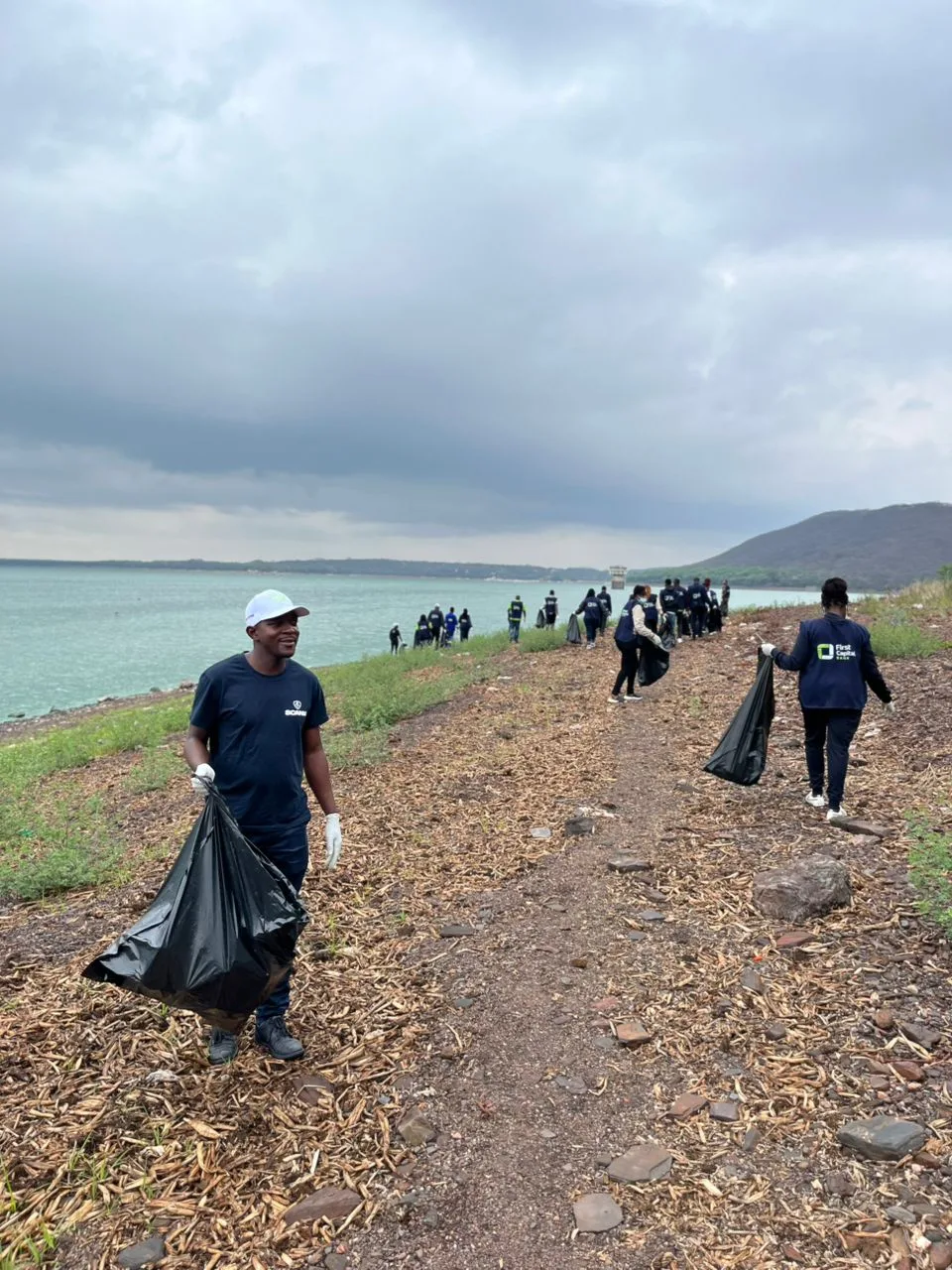 Scanlink team members participating in a lakeside waste clean-up
