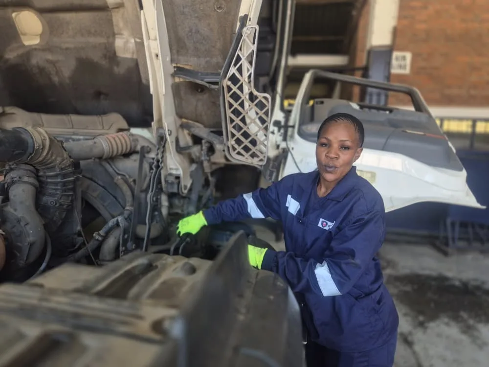 Scanlink technician servicing a truck engine bay